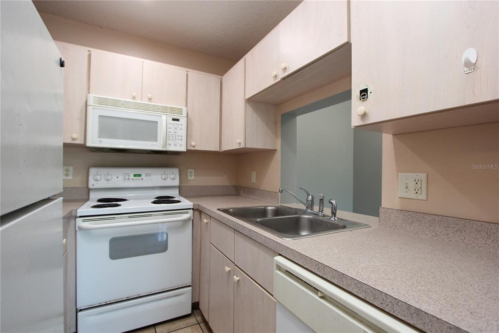 1131 South Pine Ridge Circle, Unit 1 Sanford, FL 32773 - Photo 9 of 19 a kitchen with white cabinets stainless steel appliances and sink
