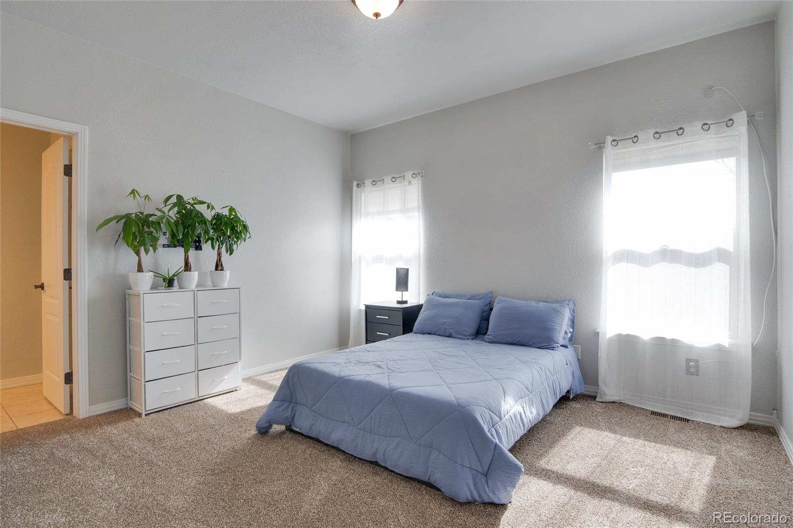 271 Corvette Circle Fort Lupton, CO 80621 - Photo 13 of 39 a bedroom with a bed and a window