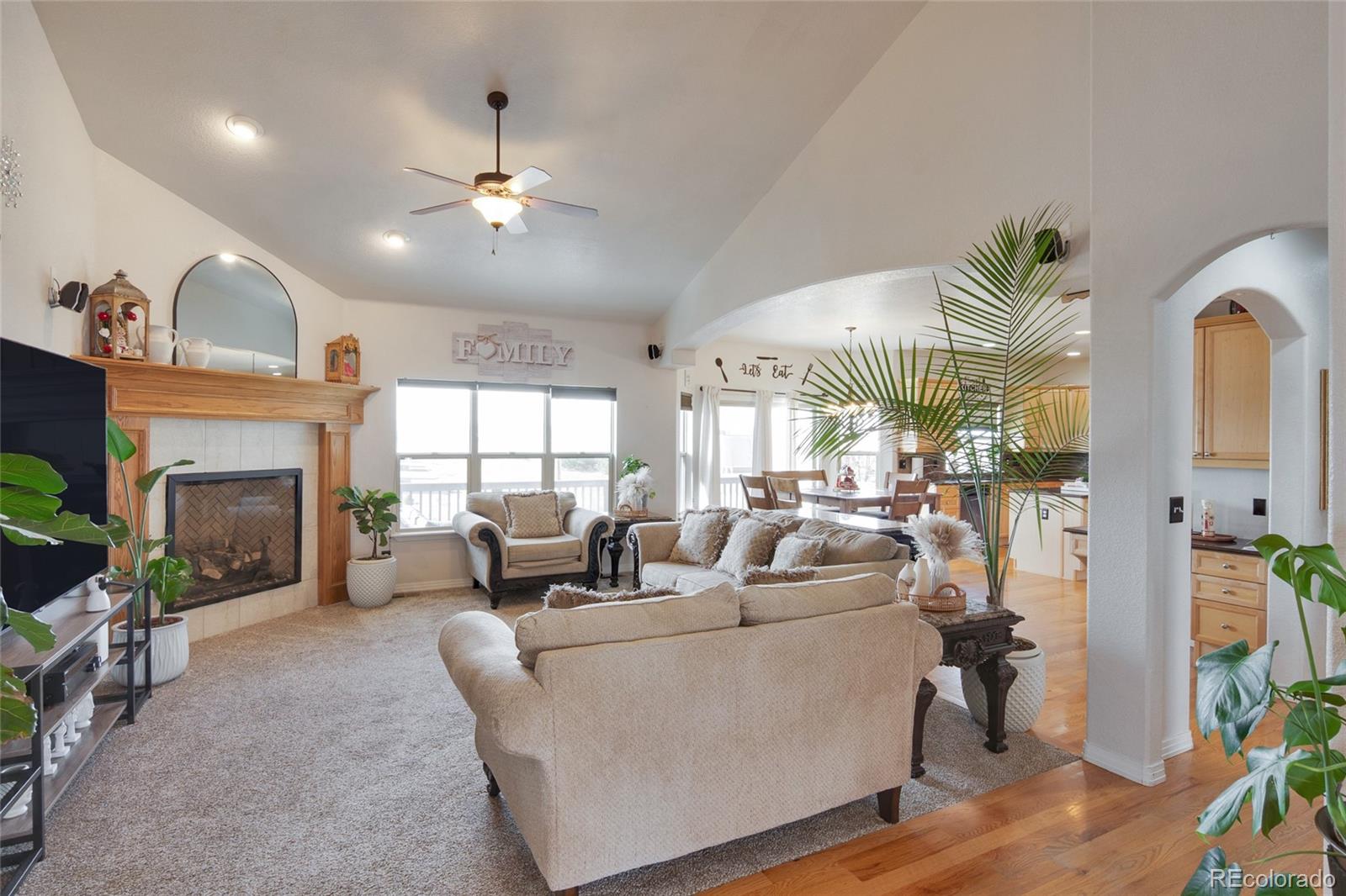 271 Corvette Circle Fort Lupton, CO 80621 - Photo 15 of 39 a living room with furniture a fireplace and a chandelier