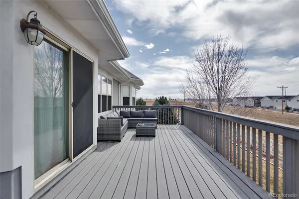 a view of a balcony with chairs and wooden floor