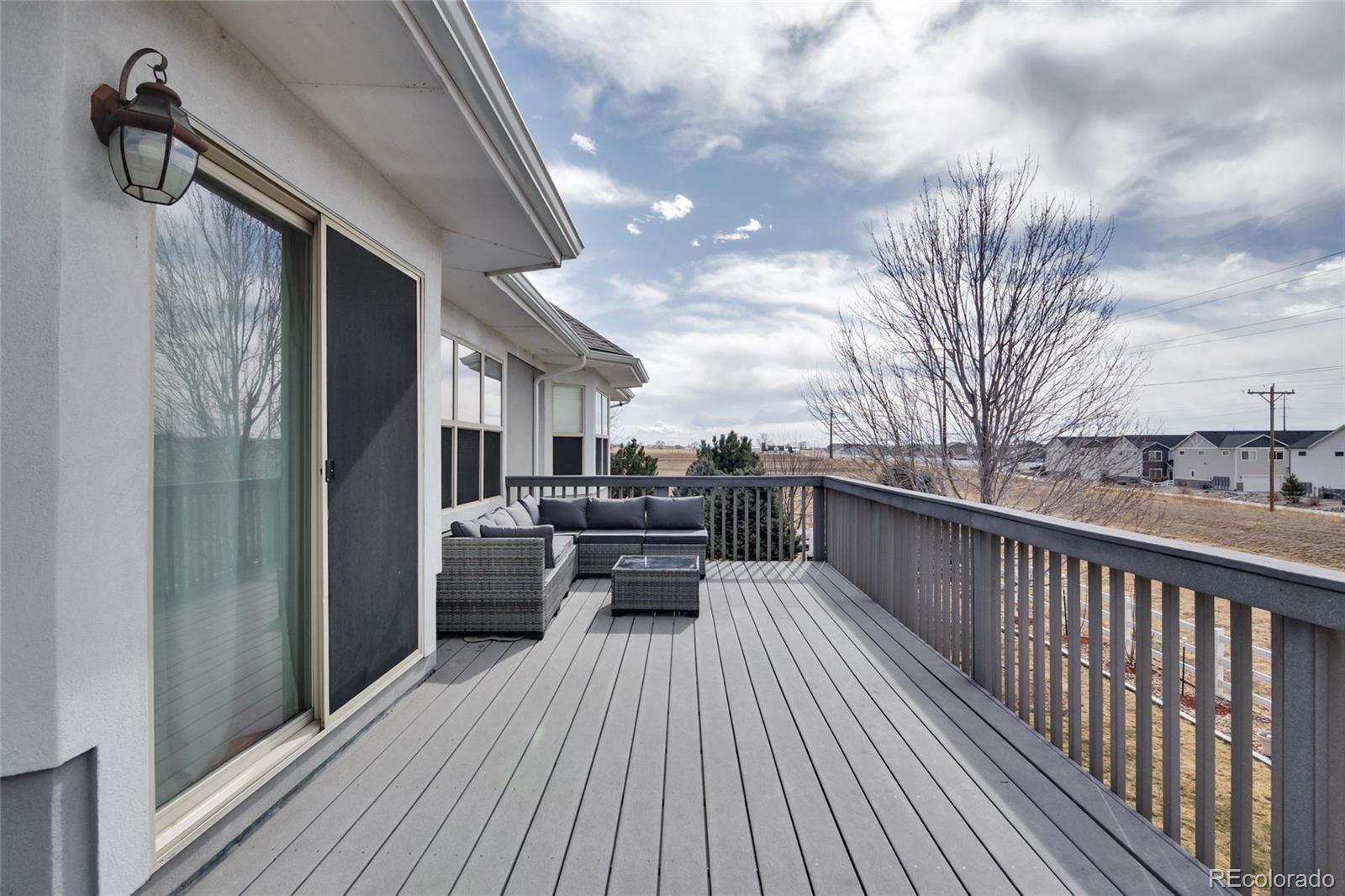 271 Corvette Circle Fort Lupton, CO 80621 - Photo 21 of 39 a view of a balcony with chairs and wooden floor