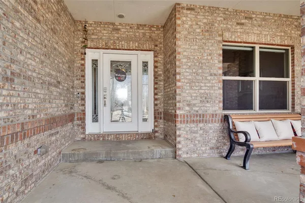a view of a brick house with a bench and a window