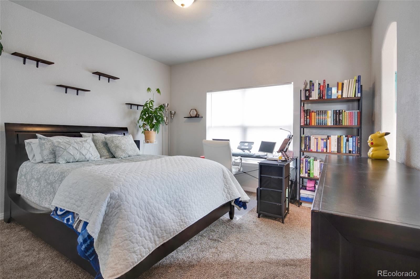 271 Corvette Circle Fort Lupton, CO 80621 - Photo 7 of 39 a bedroom with a bed and a book shelf