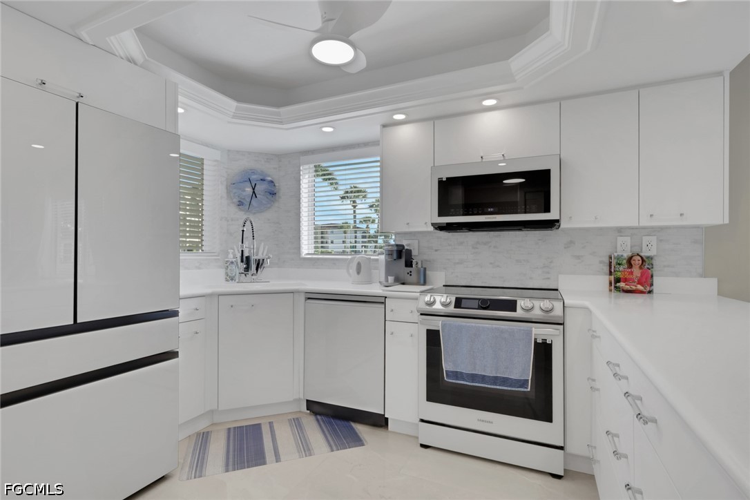 9 High Point Circle North, Unit 101 Naples, FL 34103 - Photo 14 of 49 a kitchen with a stove and a microwave