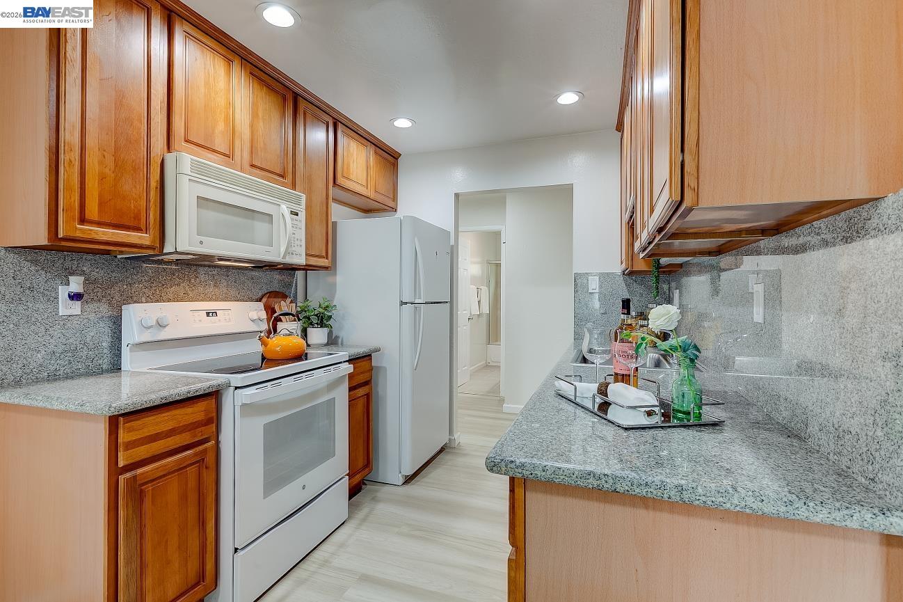 9005 Alcosta Boulevard, Unit 199 San Ramon, CA 94583 - Photo 26 of 57 a kitchen with stainless steel appliances granite countertop a sink a refrigerator and a granite counter tops