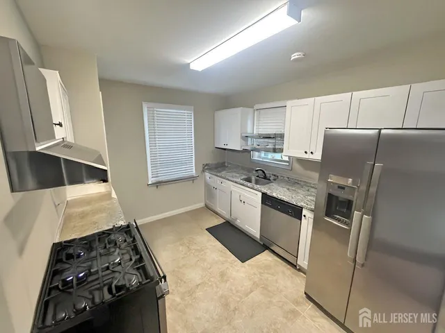 a kitchen with a stove a refrigerator and a sink