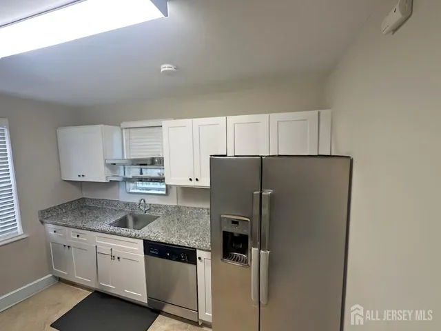 a kitchen with a refrigerator sink and cabinets