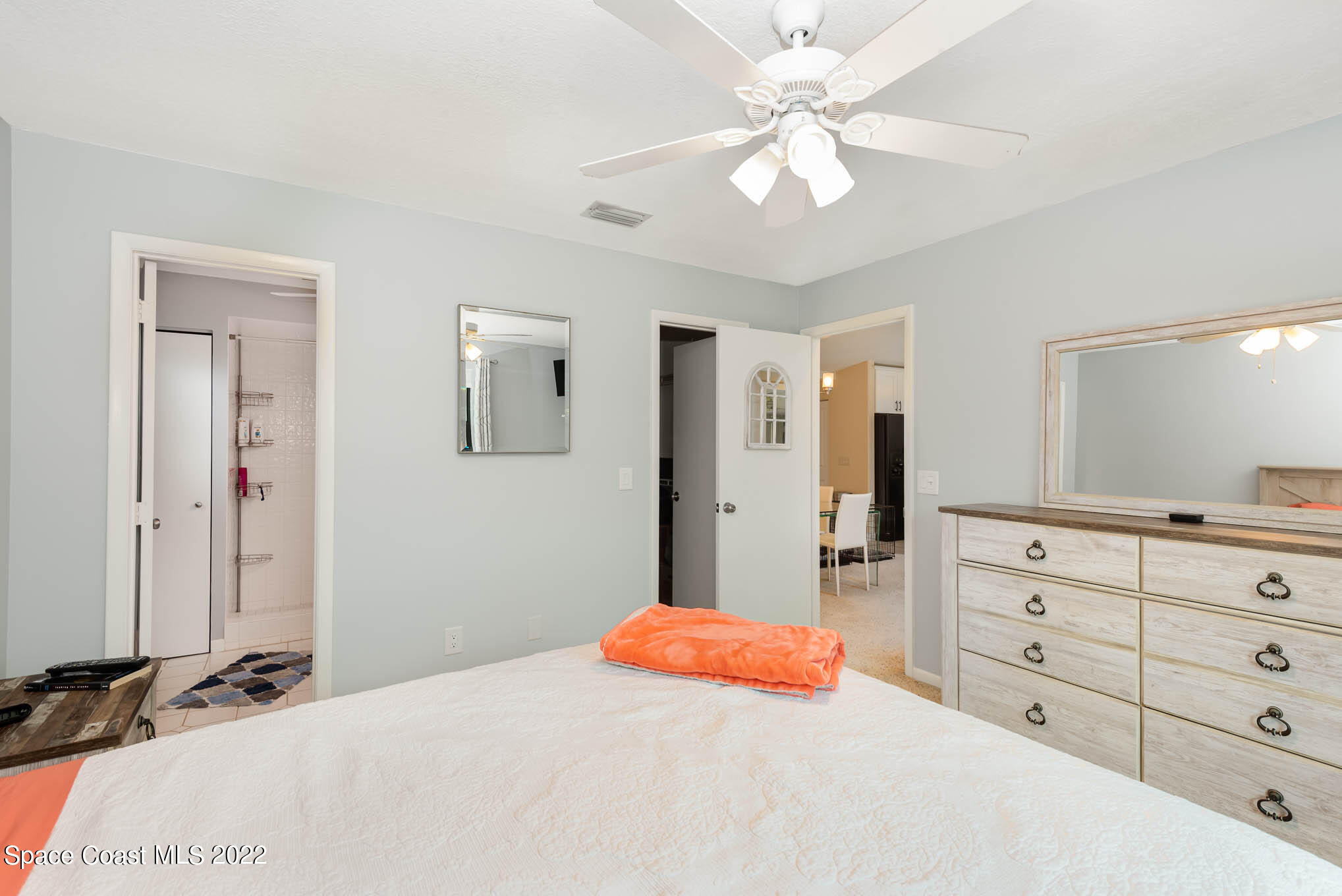 115 Normandy Place Melbourne Beach, FL 32951 - Photo 11 of 31 a bedroom with a bed a chandelier and a mirror