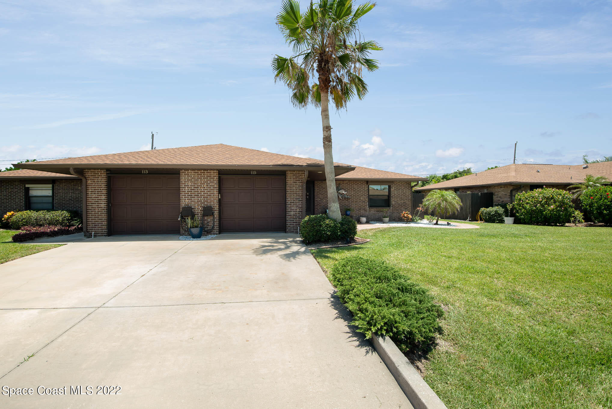 115 Normandy Place Melbourne Beach, FL 32951 - Photo 2 of 31 a front view of a house with a yard and garage