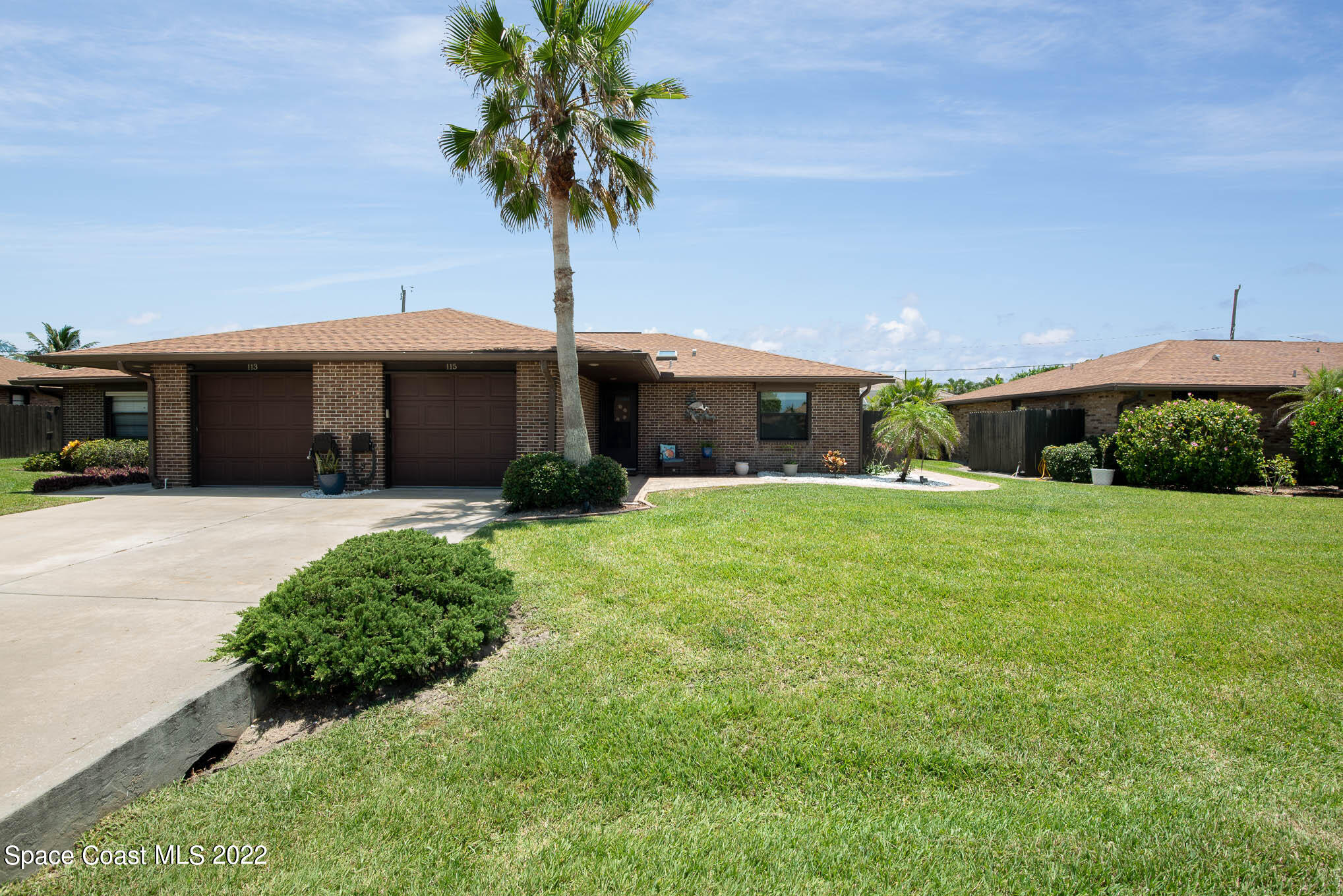 115 Normandy Place Melbourne Beach, FL 32951 - Photo 24 of 31 a front view of a house with a yard and garage