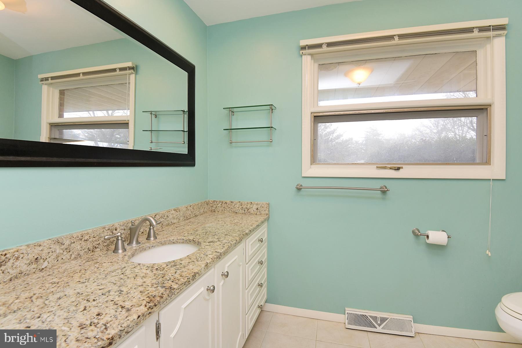 28 West Church Road Lawrence Township, NJ 08648 - Photo 26 of 32 a bathroom with a granite countertop toilet sink and mirror