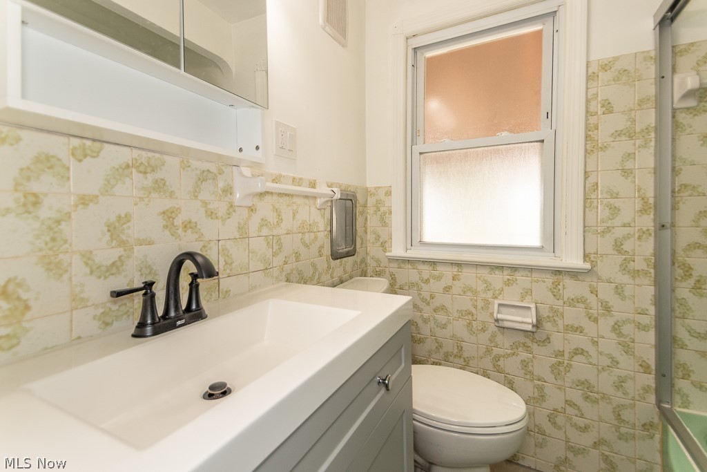 4210 Redfern Road Parma, OH 44134 - Photo 24 of 46 Bathroom featuring vanity, backsplash, tile walls, and toilet