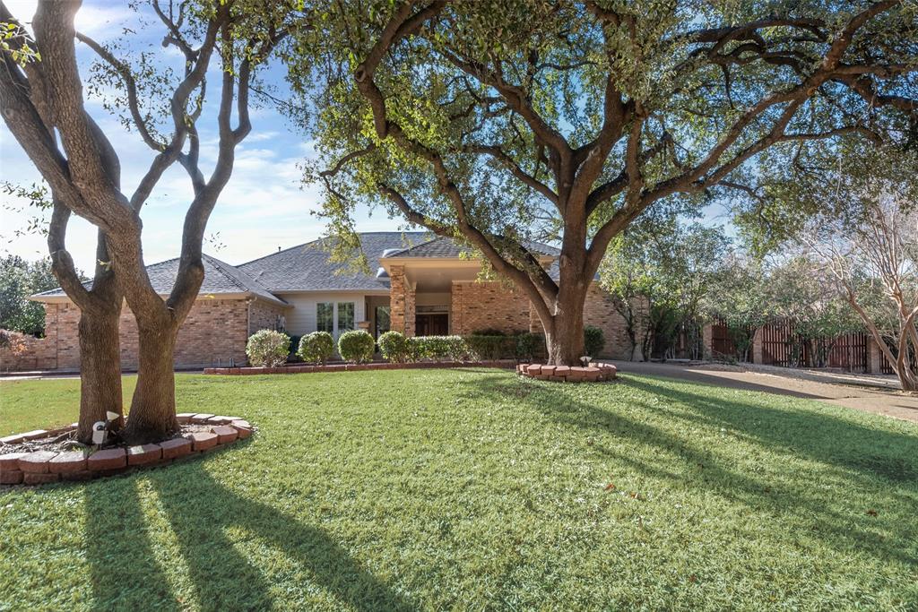 a view of a house with backyard and trees
