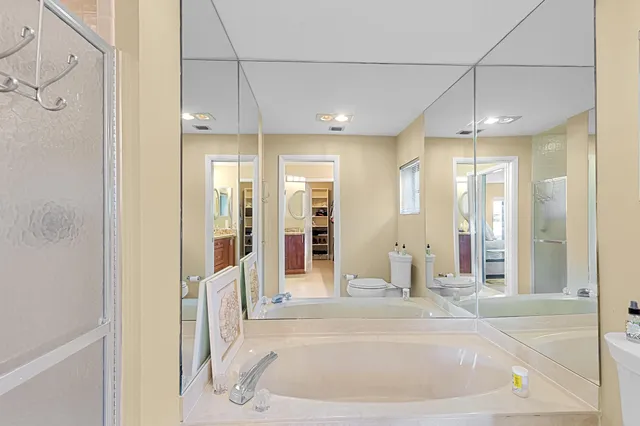 a bathroom with a granite countertop double vanity and a mirror