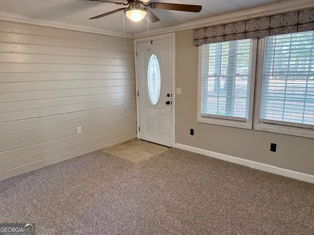 a view of an empty room with window and cabinet area