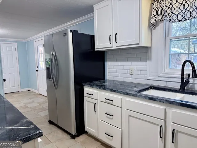 a kitchen with granite countertop white cabinets and stainless steel appliances