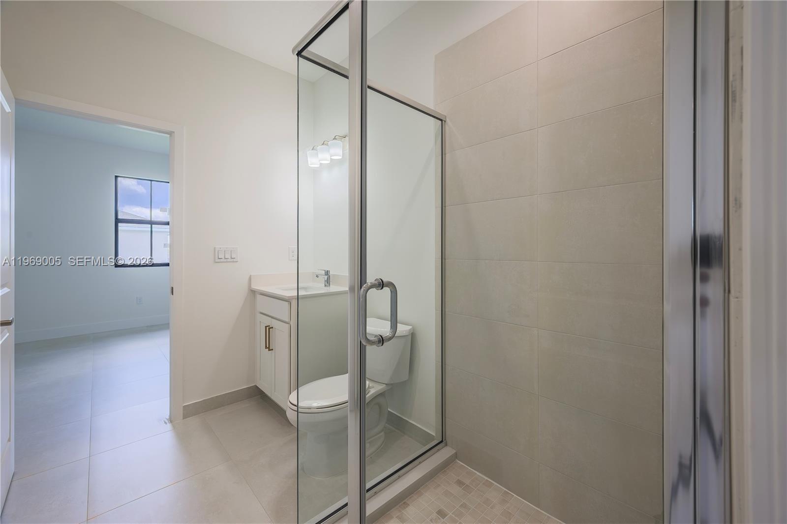32242 Southwest 194th Avenue Homestead, FL 33030 - Photo 20 of 42 a bathroom with a glass shower door