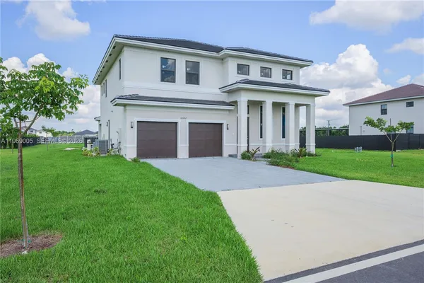 a front view of a brick house with a yard