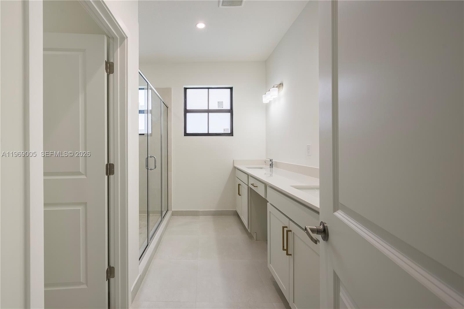 32242 Southwest 194th Avenue Homestead, FL 33030 - Photo 24 of 42 a bathroom with a sink a mirror and a shower