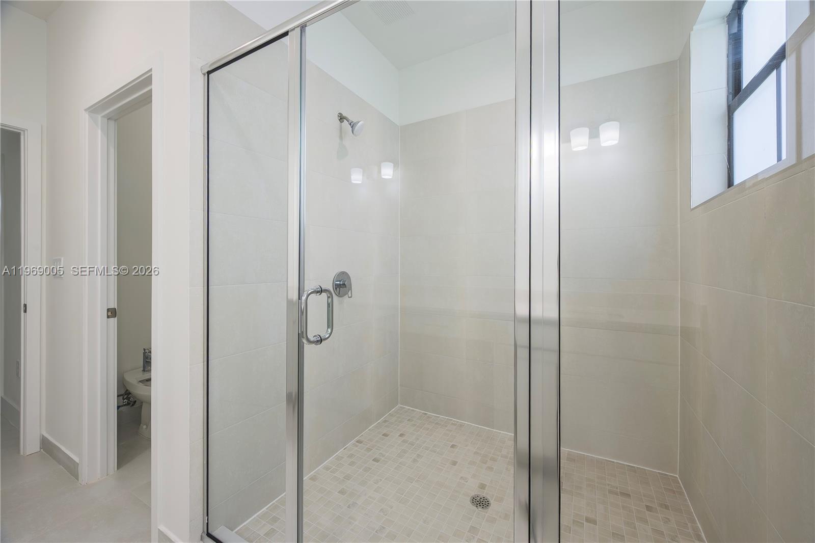 32242 Southwest 194th Avenue Homestead, FL 33030 - Photo 26 of 42 a bathroom with a glass shower door