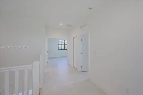a view of an empty room with windows and closet