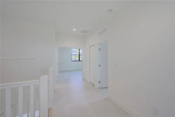 a view of an empty room with windows and closet