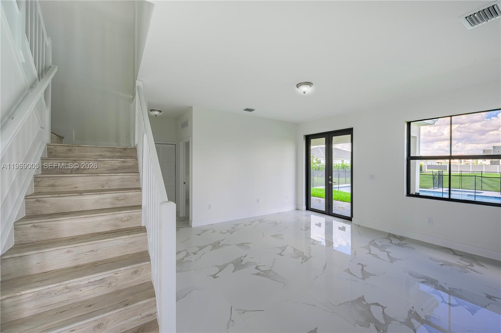 32242 Southwest 194th Avenue Homestead, FL 33030 - Photo 7 of 42 a view of an empty room with wooden floor and a window