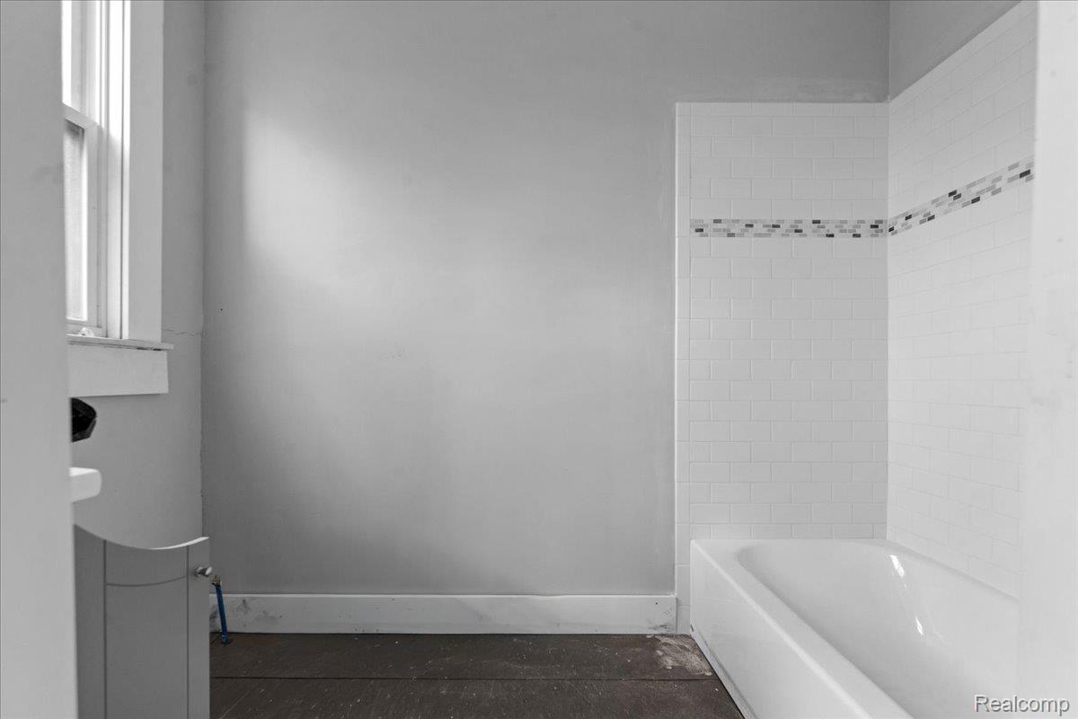 58 East Philadelphia Street Detroit, MI 48202 - Photo 19 of 24 Bathtub with white subway tile surround and decorative mosaic accent band