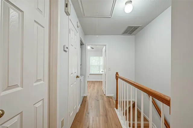 a view of a hallway with wooden floor and staircase