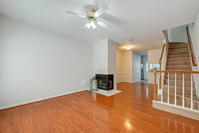 an empty room with windows and ceiling fan