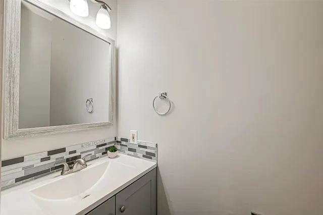 a bathroom with a sink vanity and mirror