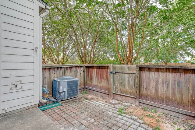 a backyard of a house with lawn chairs and wooden fence