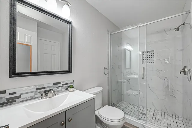 a bathroom with a sink a toilet and shower