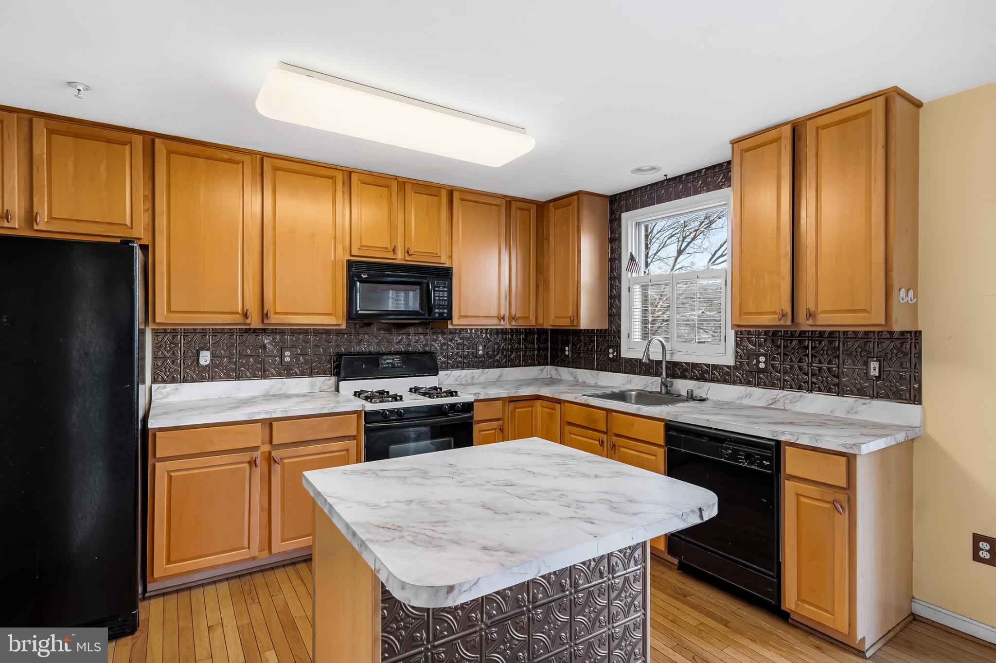 252 Robert Street Baltimore, MD 21217 - Photo 15 of 51 a kitchen with a stove a sink a microwave a refrigerator and cabinets
