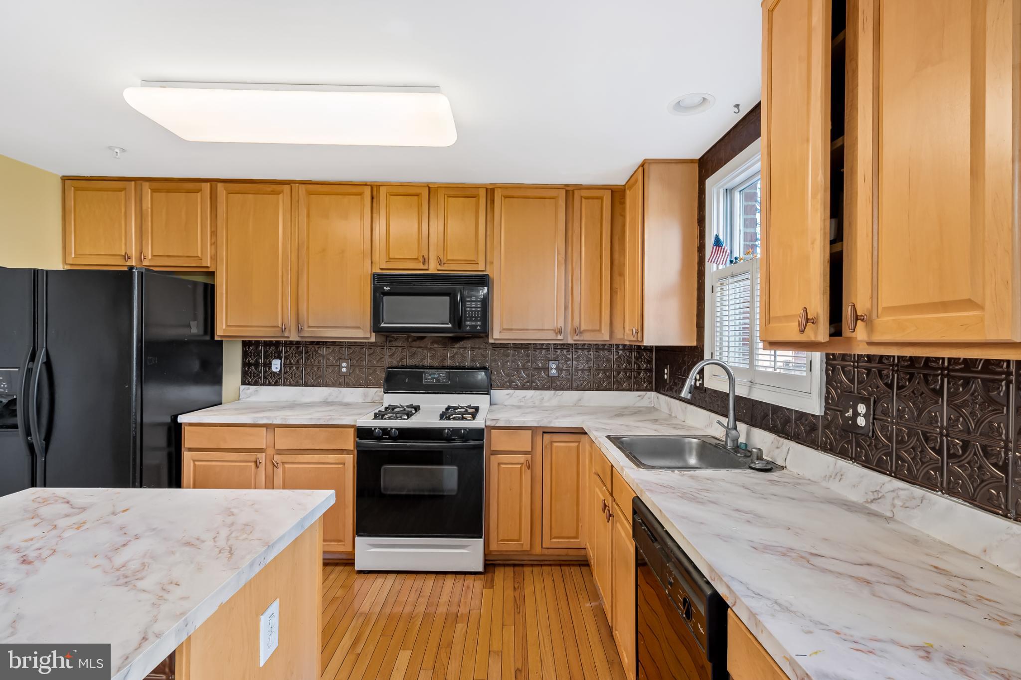 252 Robert Street Baltimore, MD 21217 - Photo 16 of 51 a kitchen with a stove a sink a microwave a refrigerator and cabinets