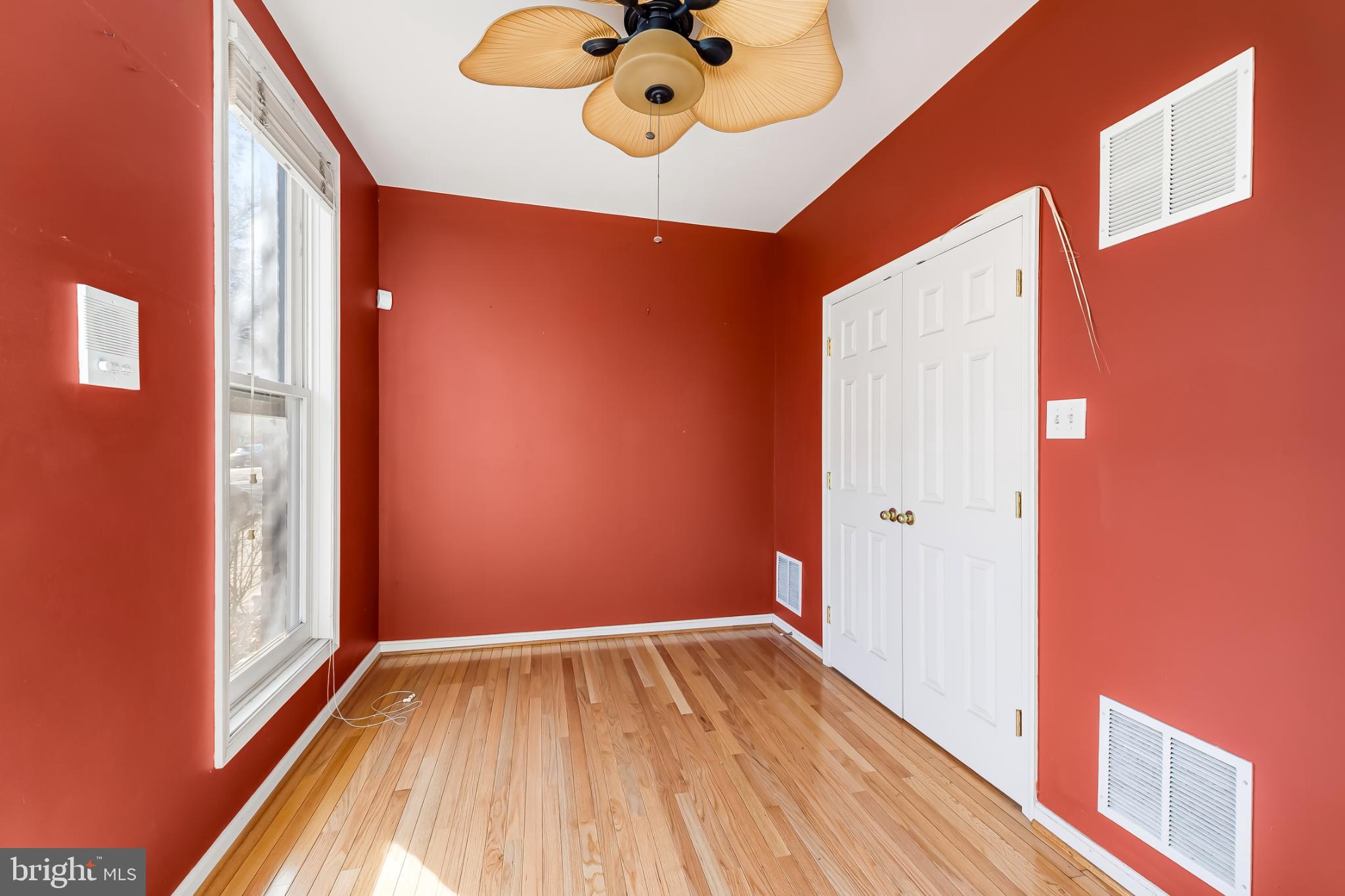 252 Robert Street Baltimore, MD 21217 - Photo 6 of 51 a view of an empty room with a window and wooden floor