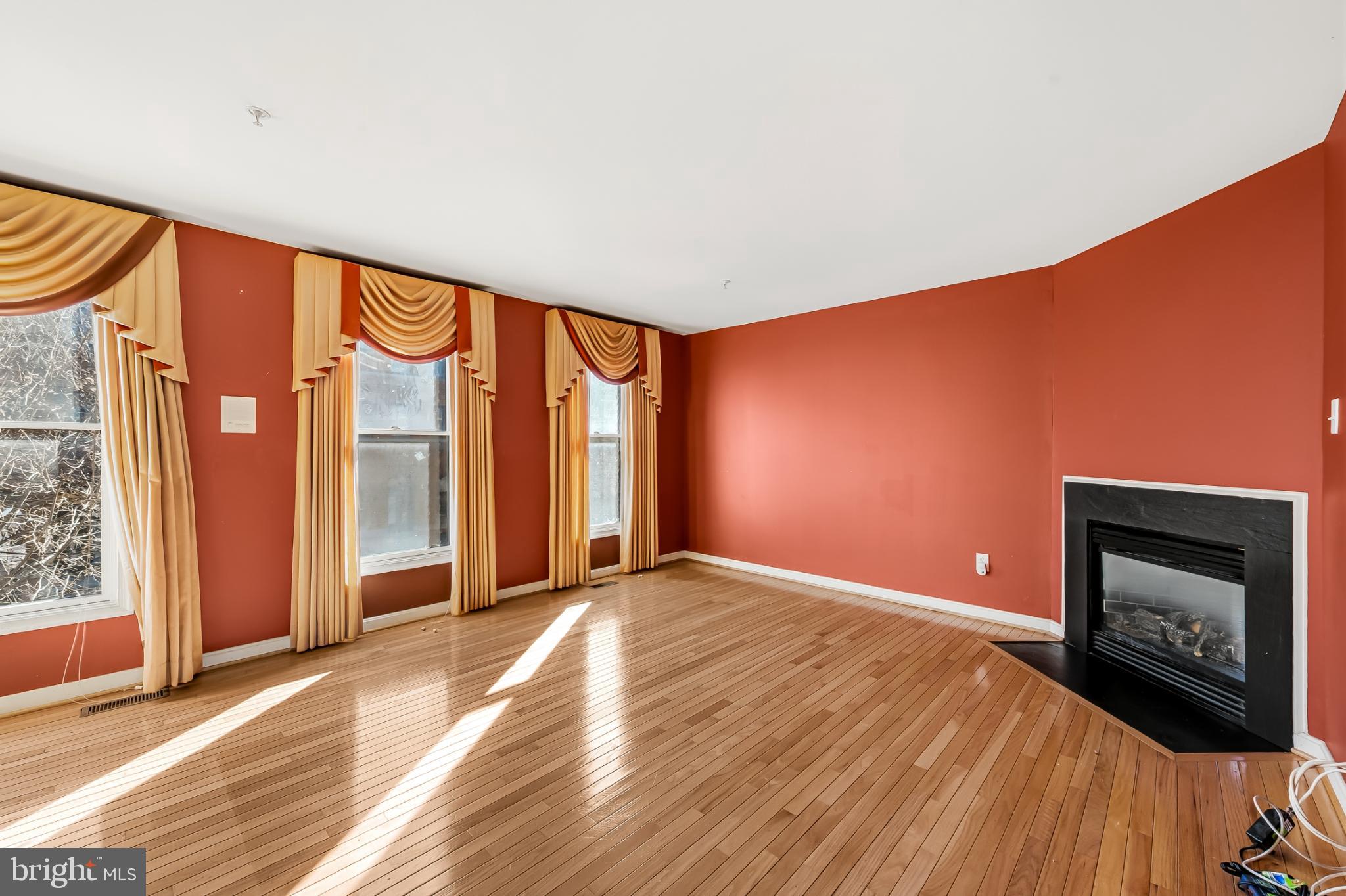 252 Robert Street Baltimore, MD 21217 - Photo 9 of 51 a view of an empty room with a fireplace and a window