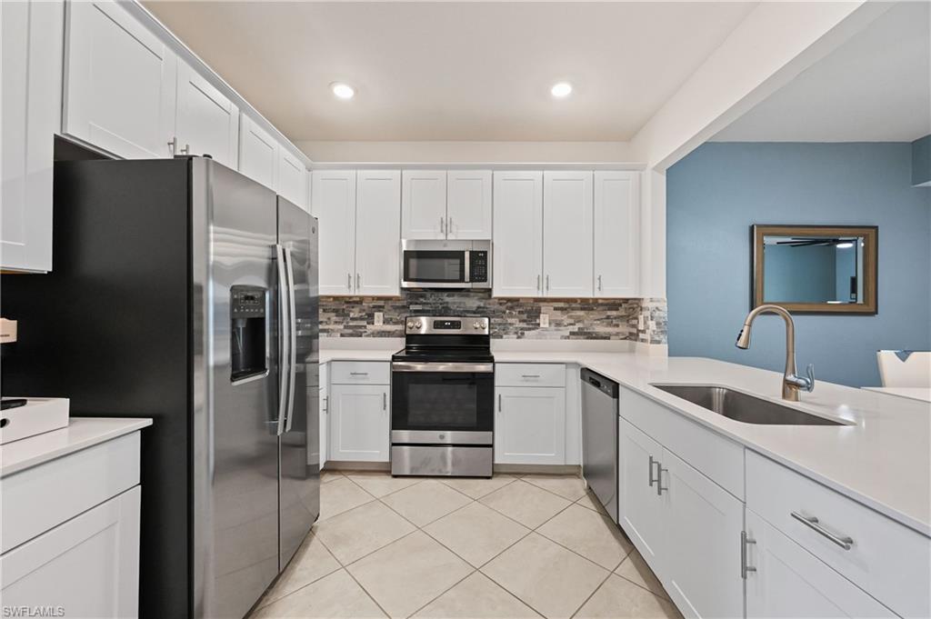 2828 Citrus Street Naples, FL 34120 - Photo 4 of 40 a kitchen with white cabinets stainless steel appliances and a sink