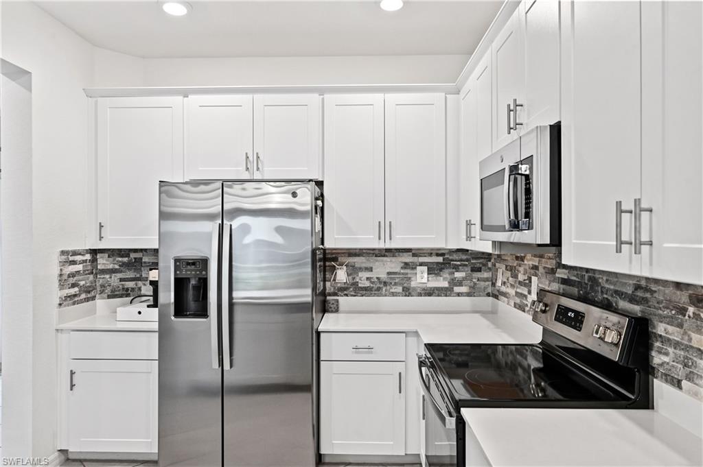2828 Citrus Street Naples, FL 34120 - Photo 6 of 40 a kitchen with a refrigerator and a stove top oven