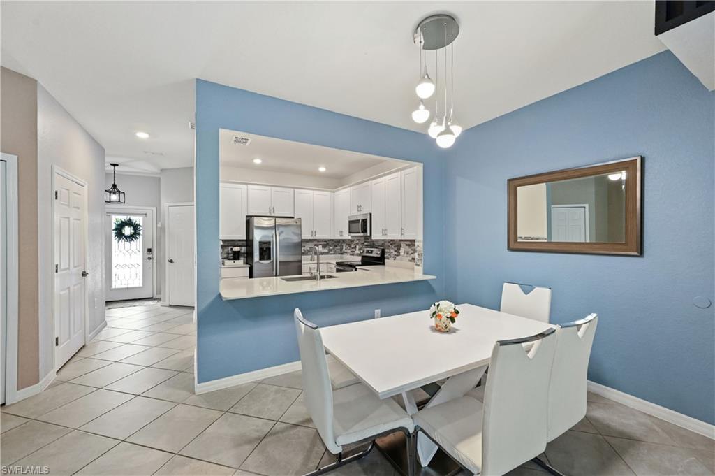 2828 Citrus Street Naples, FL 34120 - Photo 9 of 40 a dining room with wooden floor a chandelier a wooden table and chairs