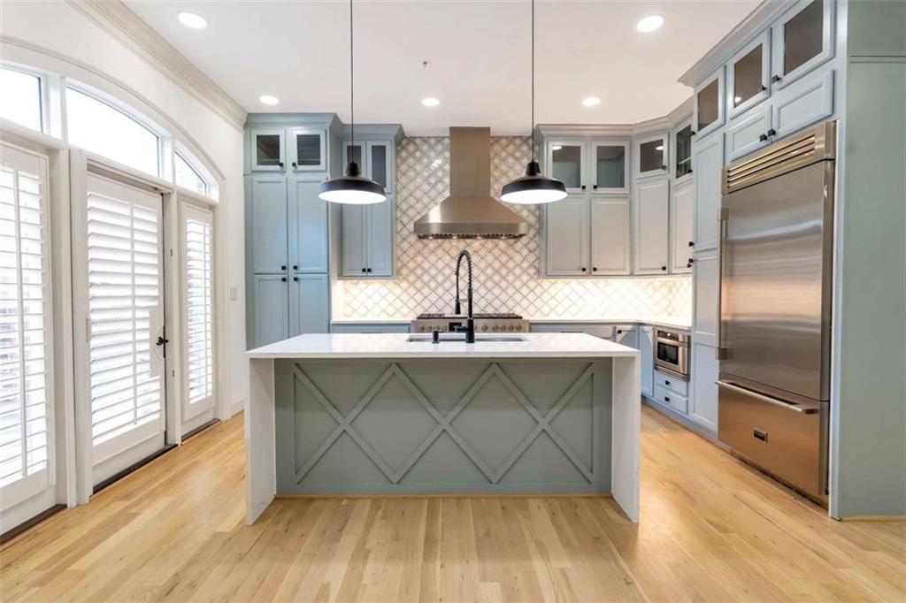 201 Riversgate Drive Atlanta, GA 30339 - Photo 23 of 69 a kitchen with stainless steel appliances a dining table chairs wooden floor and a large window