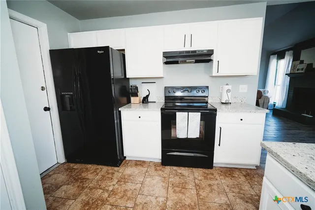 a kitchen with stainless steel appliances granite countertop a refrigerator stove and a sink