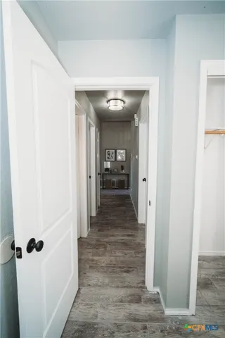 a view of a hallway with wooden floor and staircase
