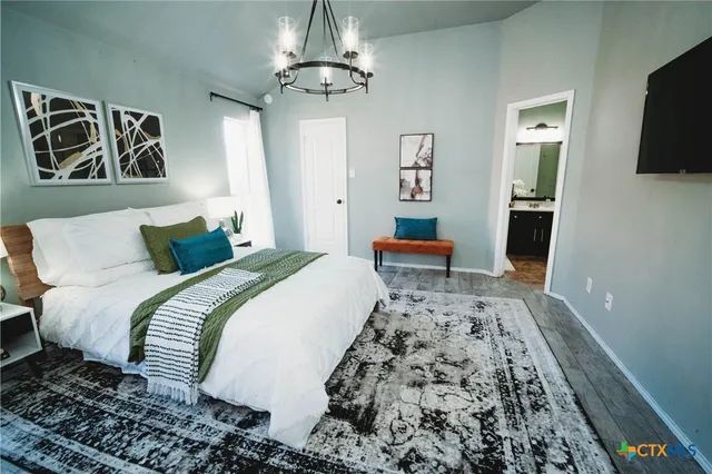 a bedroom with bed and wooden floor