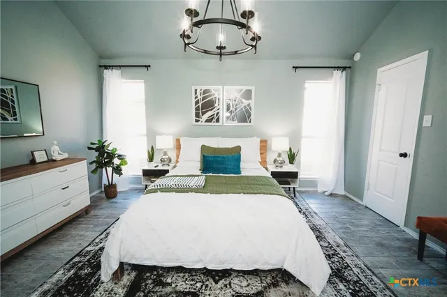 a bedroom with a large bed and a chandelier