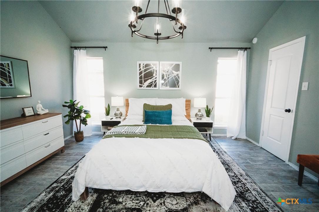 2607 Rampart Loop Killeen, TX 76542 - Photo 18 of 34 a bedroom with a large bed and a chandelier