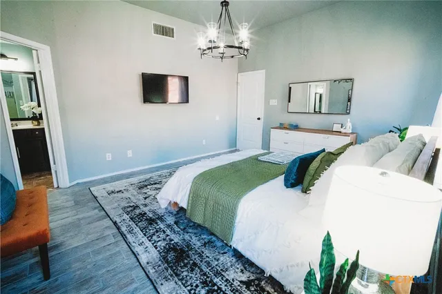 a bedroom with a bed and a chandelier