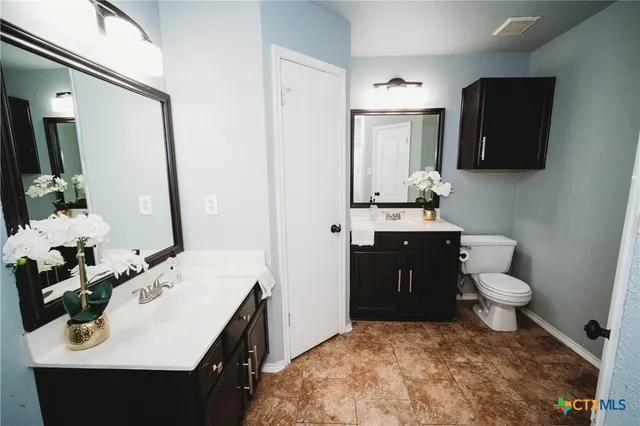 a bathroom with a sink vanity and toilet