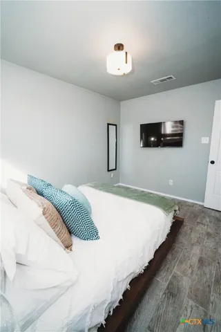 a bedroom with a bed and a flat screen tv