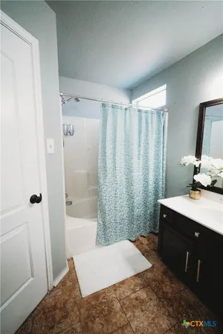 a bathroom with a sink a toilet a mirror and shower